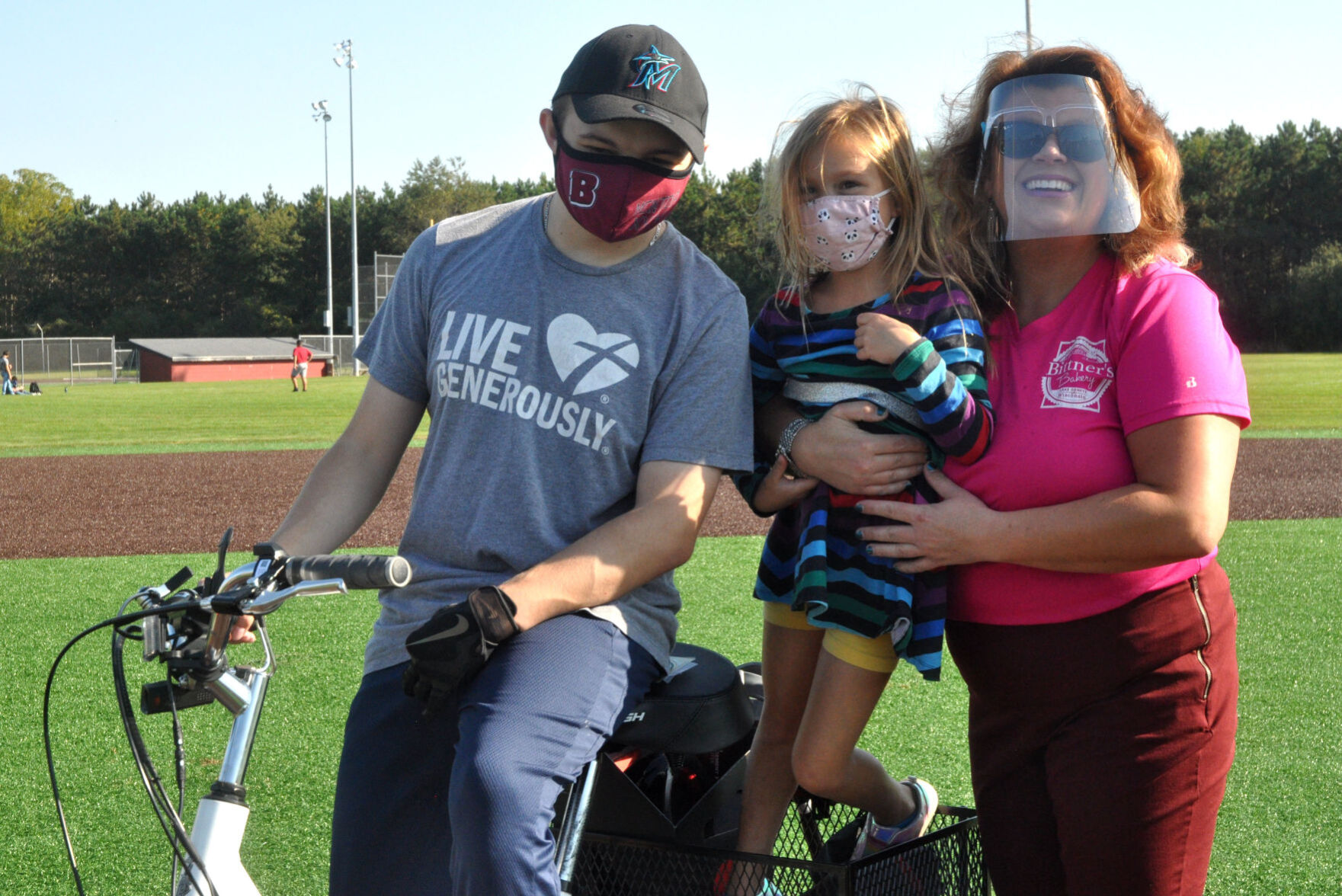 Brooks Guif, from left, Lorelei Bittner and Amy Peterburs-Bittner stand on the pitchers mound